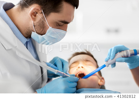 dentist treating kid teeth at dental clinic 41302812