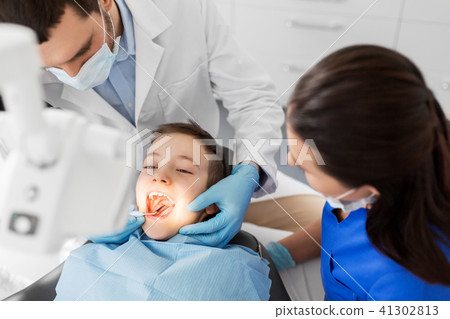 dentist checking for kid teeth at dental clinic 41302813