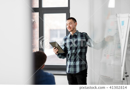 man showing tablet pc to creative team at office 41302814