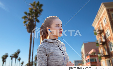 woman with earphones running over venice beach woman with earphones running over venice beach 41302868