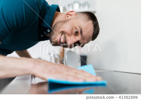 man with rag cleaning cooker at home kitchen man with rag cleaning cooker at home kitchen 41302899