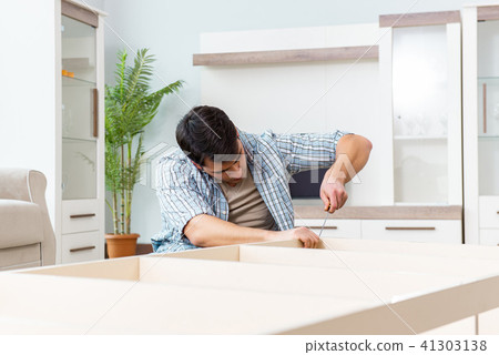 Man assembling furniture at home Man assembling furniture at home 41303138