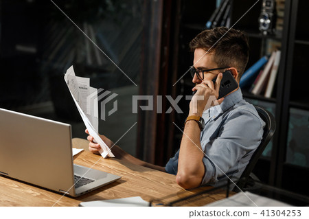 Diligent worker with papers speaking on phone Diligent worker with papers speaking on phone 41304253
