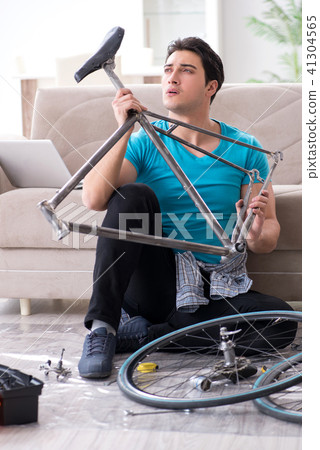 Young man repairing bicycle at home Young man repairing bicycle at home 41304565
