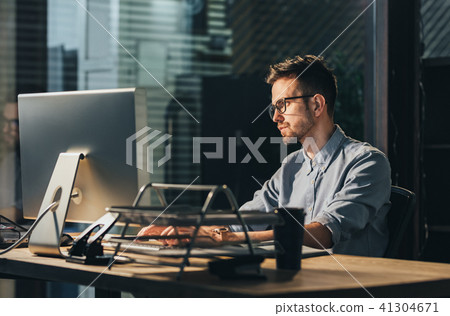 Exhausted man working overtime in office Exhausted man working overtime in office 41304671
