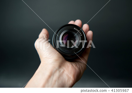 Hand, left hand, camera lens, DSLR lens, black background Hand, left hand, camera lens, DSLR lens, black background 41305987