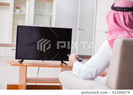 Arab businessman watching tv at home 41306074