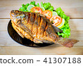 fried fish with vegetable on black dish. top view 41307188