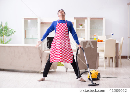 Young man vacuum cleaning his apartment 41309032