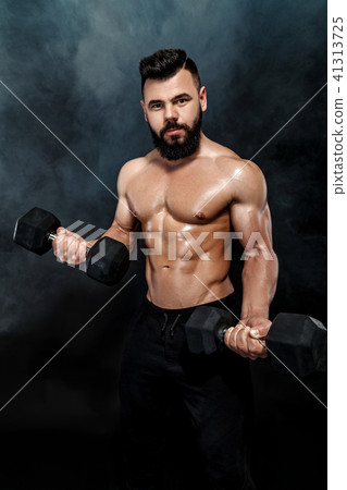athletic muscular man doing exercises with dumbbells. athletic muscular man doing exercises with dumbbells. 41313725
