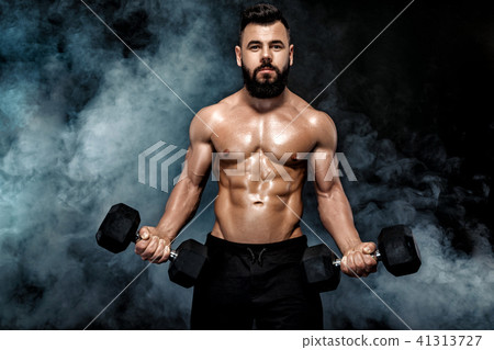 athletic muscular man doing exercises with dumbbells. athletic muscular man doing exercises with dumbbells. 41313727