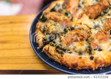 Pizza served on wooden circle board Pizza served on wooden circle board 41315108
