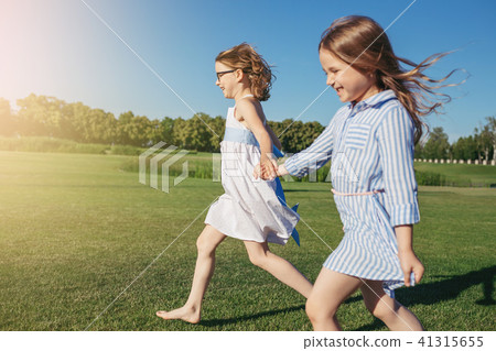 Two joyfull girls running on the field. Two joyfull girls running on the field. 41315655