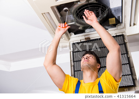 Repairman repairing ceiling air conditioning unit Repairman repairing ceiling air conditioning unit 41315664
