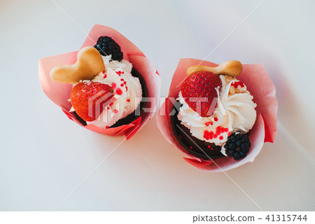 cupcakes with cream and fresh strawberries and BlackBerry 41315744