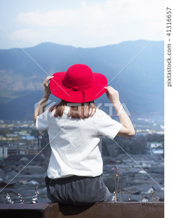 World Heritage Lijiang ancient castle A woman with a red hat staring at the streets 41316657