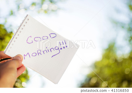 Man holding a notebook that says good morning. Man holding a notebook that says good morning. 41316850
