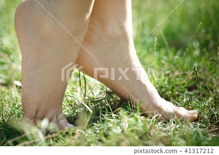 female legs walking on green grass 41317212