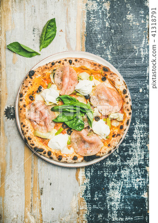 Freshly baked pizza with ham, artichokes, cheese, basil, top view Freshly baked pizza with ham, artichokes, cheese, basil, top view 41318791