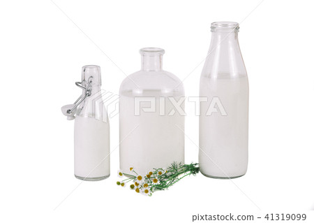 three different bottles of milk with chamomile 41319099
