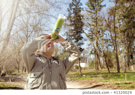 Boy looking at the kaleidoscope outdoors 41320029