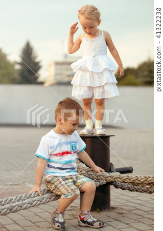 Happy family brother and sister playing on the embankment Happy family brother and sister playing on the embankment 41322238