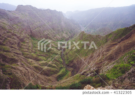 Breathtaking panorama of a steep gorge with haze riverbed and lush green vegetation in the valley of Breathtaking panorama of a steep gorge with haze riverbed and lush green vegetation in the valley of 41322305