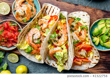 Shrimps tacos with salsa, vegetables and avocado. Mexican food Shrimps tacos with salsa, vegetables and avocado. Mexican food 41322758