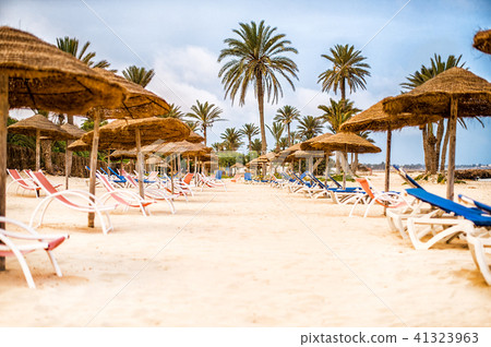 Sunbeds with parasols on snow-white sand on beach 41323963