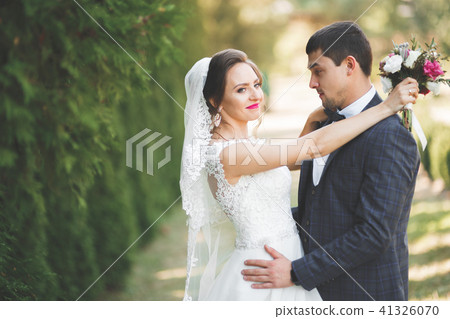 Perfect couple bride, groom posing and kissing in their wedding day Perfect couple bride, groom posing and kissing in their wedding day 41326070