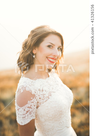 Happy beautiful bride outside on a summer meadow at the sunset with perfect view 41326156