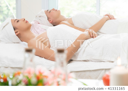 Relaxed young woman lying on spa bed for massage. 41331165