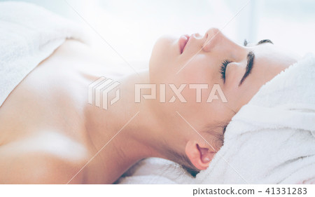 Relaxed young woman lying on spa bed for massage. Relaxed young woman lying on spa bed for massage. 41331283