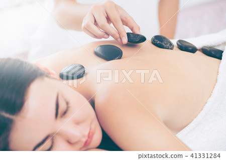 Hot stone massage treatment by therapist in spa. Hot stone massage treatment by therapist in spa. 41331284