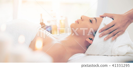 Relaxed woman gets facial and head massage in spa. 41331295