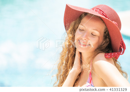 Happy young woman in swimsuit at swimming pool. 41331329