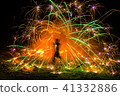 fire twirler dancing with firework light effects 41332886