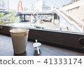 hot coffee, swizzle and syrup in front of window 41333174