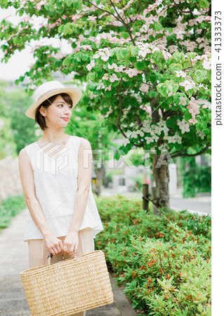Woman walking along a tree-lined road 41333373
