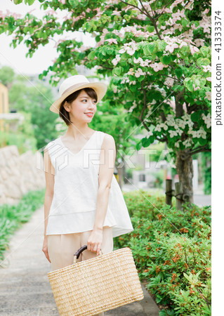 Woman walking along a tree-lined road 41333374
