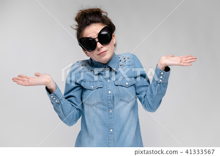 Young brunette girl in black glasses. Cat glasses. The hair is gathered in a bun. The girl spread Young brunette girl in black glasses. Cat glasses. The hair is gathered in a bun. The girl spread 41333567