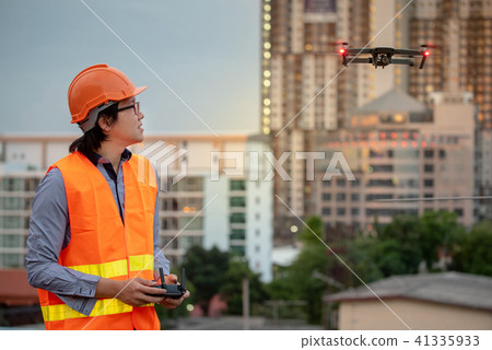 Asian engineer flying drone over construction site 41335933