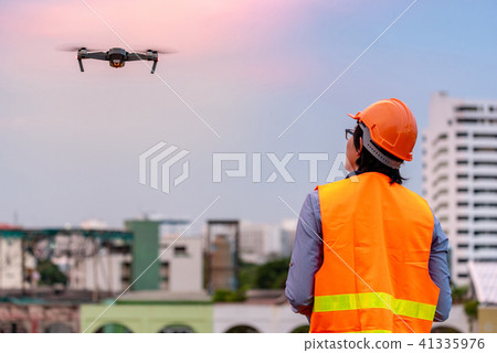 Asian engineer flying drone over construction site Asian engineer flying drone over construction site 41335976