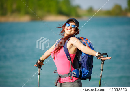 Portrait of happy female athlete with walking sticks on blurred background Portrait of happy female athlete with walking sticks on blurred background 41338850