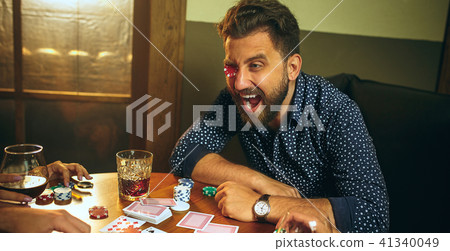 Funny photo of friends sitting at wooden table. Friends having fun while playing board game. Funny photo of friends sitting at wooden table. Friends having fun while playing board game. 41340049