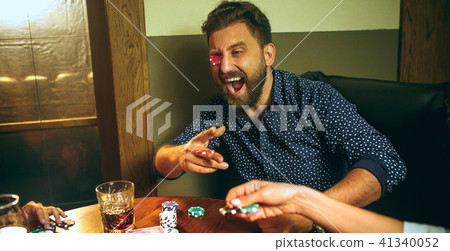 Funny photo of friends sitting at wooden table. Friends having fun while playing board game. Funny photo of friends sitting at wooden table. Friends having fun while playing board game. 41340052