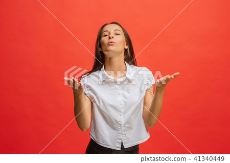 Beautiful female half-length portrait isolated on red studio backgroud. The young emotional 41340449