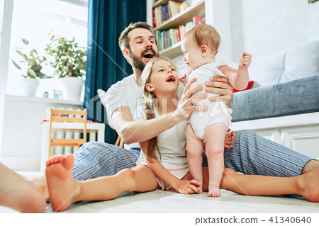 Proud father holding his newborn baby daughter at home 41340640