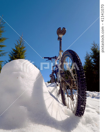 Cycling in snowy mountains on large tire wheels 41341070