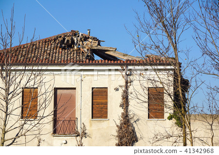 Broken brick bags on the roof of a cottage. Damaged roof. Broken brick bags on the roof of a cottage. Damaged roof. 41342968